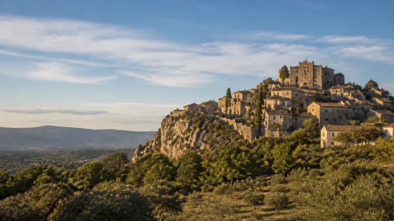 Village provençal perché sur une butte calcaire, maisons en pierre et château