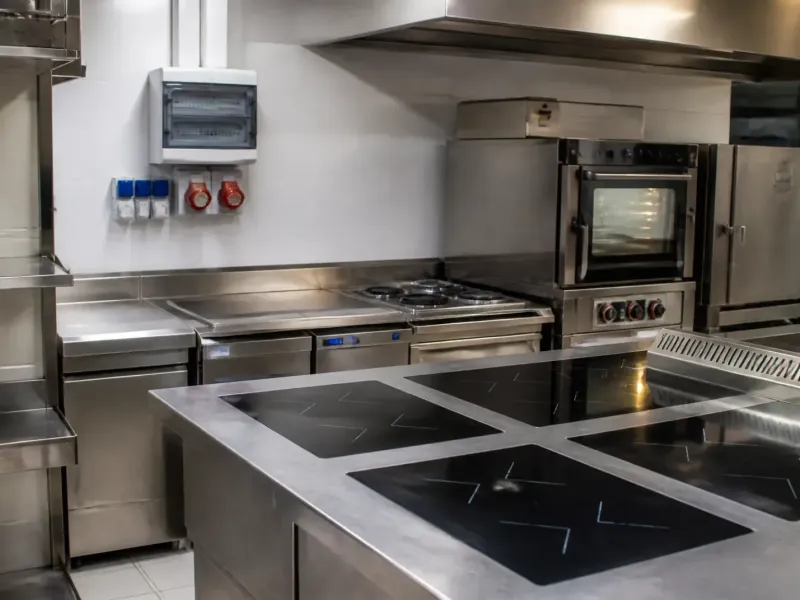 Cuisine professionnelle en inox, fours et plaques à induction alimentés en triphasé